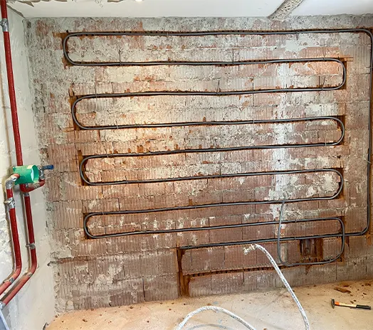 Wandheizung wird in gefräste Schlitze in der Wand verlegt